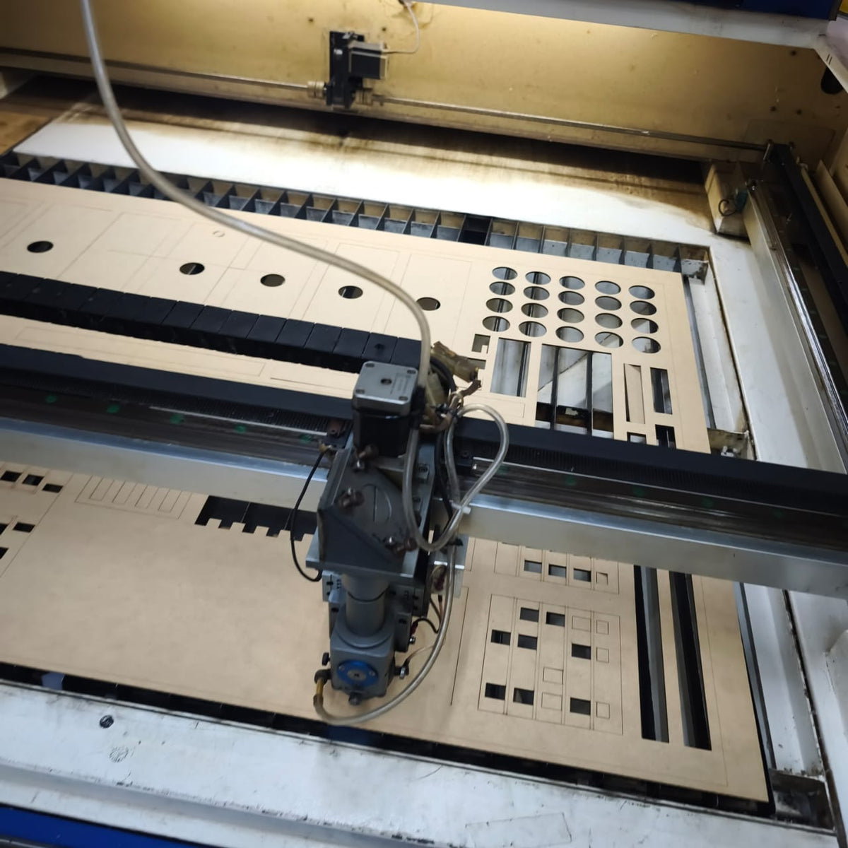 Plancha de MDF con piezas de maqueta en la cortadora láser
